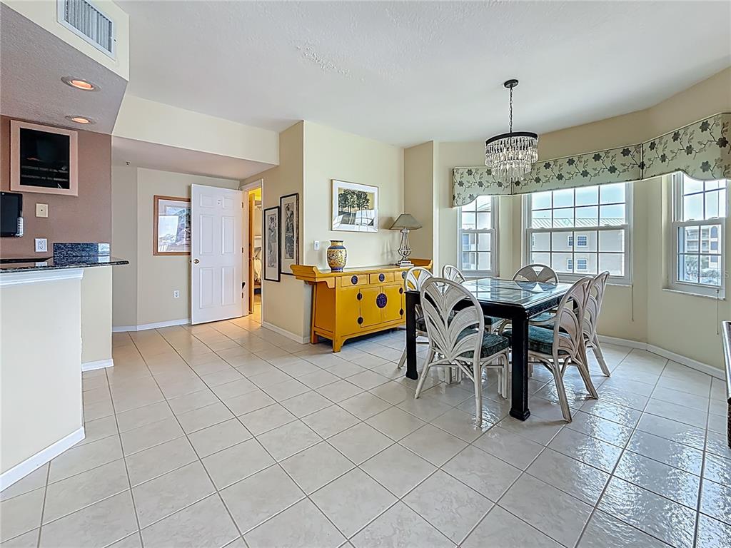 399 150th Avenue, Unit 317 Madeira Beach, FL 33708 - Photo 13 of 96 a view of a dining room with furniture and chandelier