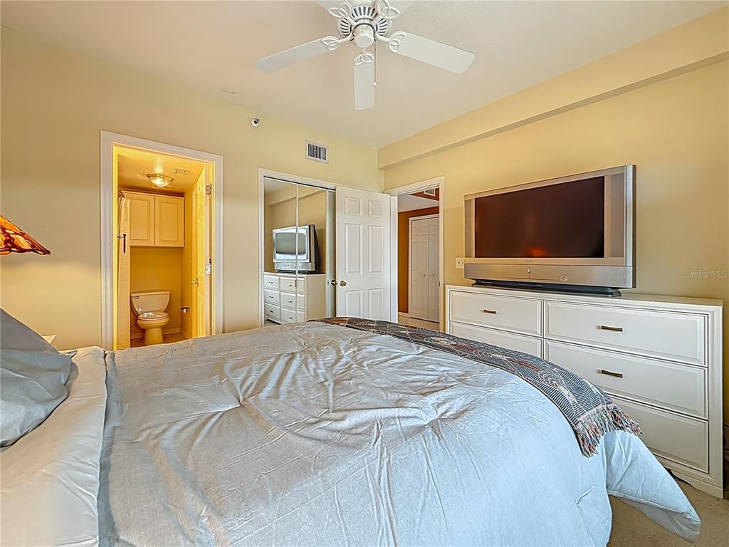 399 150th Avenue, Unit 317 Madeira Beach, FL 33708 - Photo 29 of 96 a bedroom with a bed and a flat screen tv