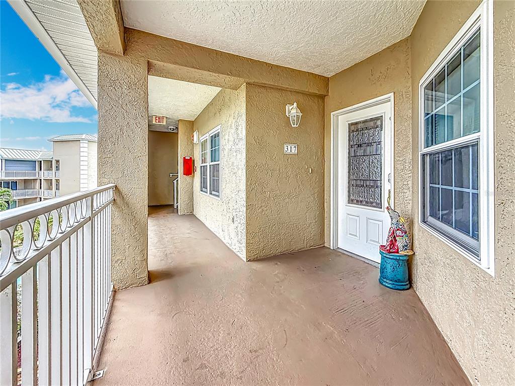 399 150th Avenue, Unit 317 Madeira Beach, FL 33708 - Photo 4 of 96 a view of a hallway with wooden floor and windows