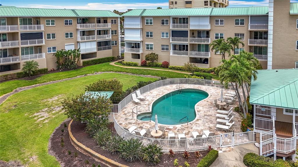 399 150th Avenue, Unit 317 Madeira Beach, FL 33708 - Photo 49 of 96 a swimming pool with outdoor seating and plants