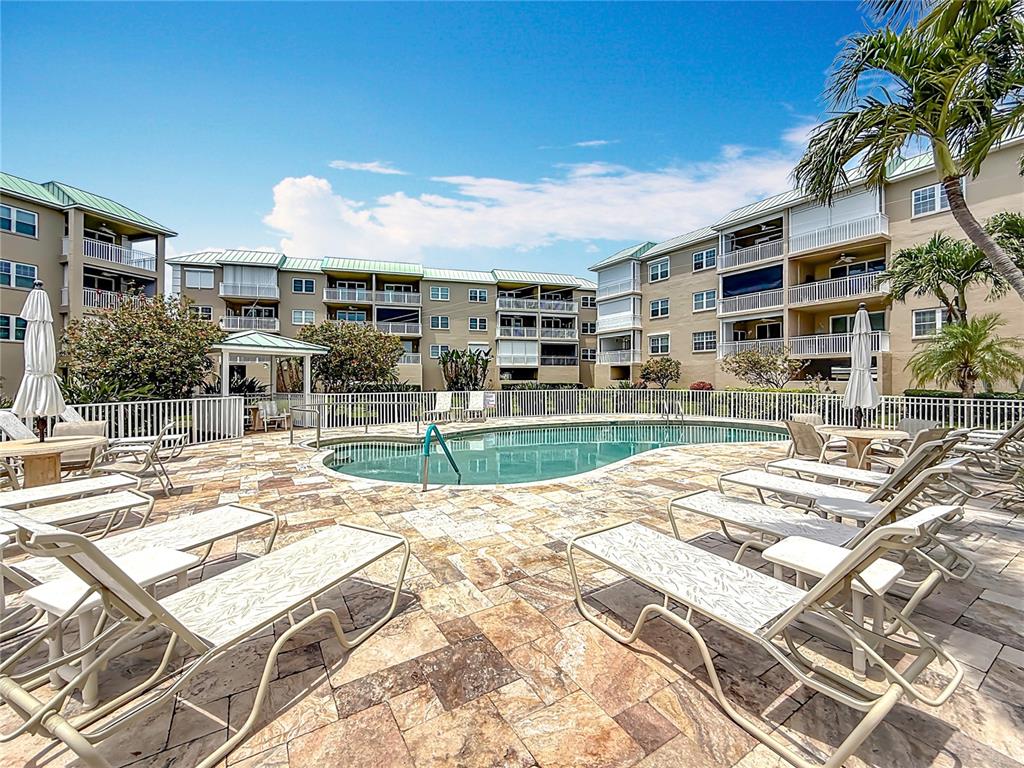399 150th Avenue, Unit 317 Madeira Beach, FL 33708 - Photo 57 of 96 a view of a swimming pool with a lounge chairs