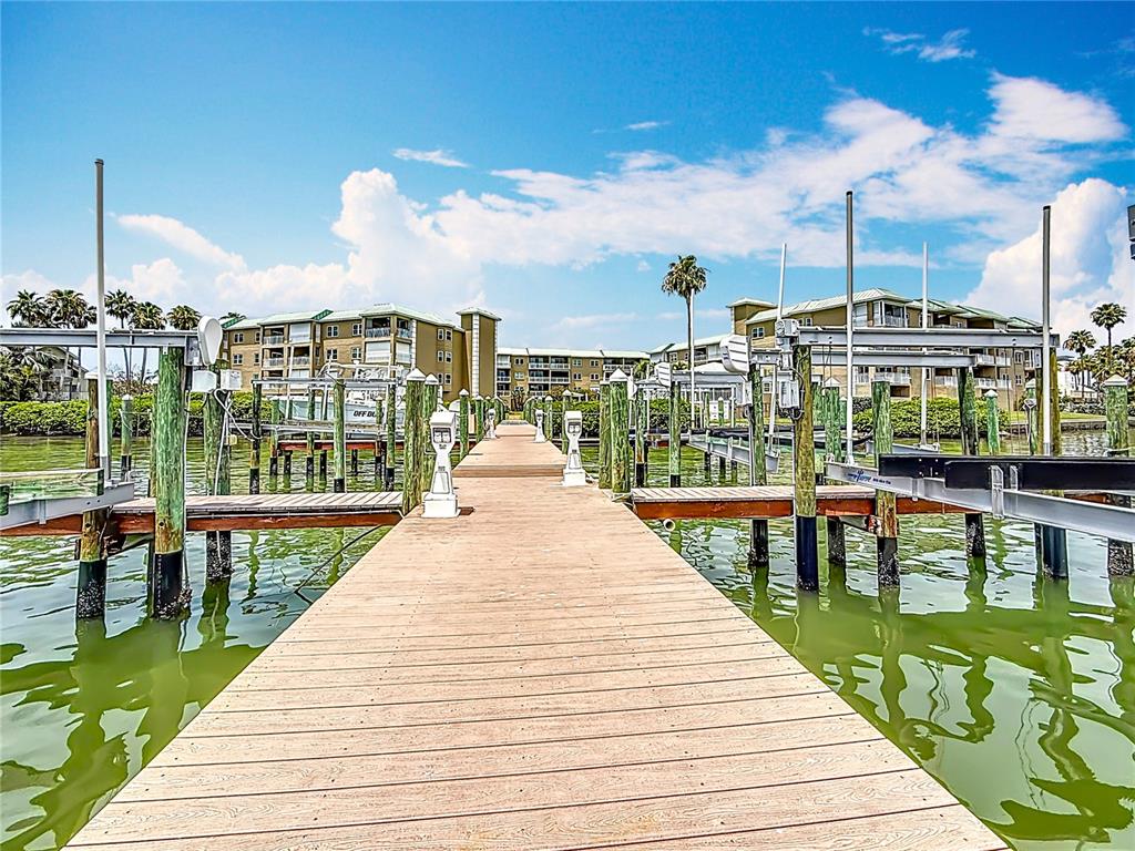 399 150th Avenue, Unit 317 Madeira Beach, FL 33708 - Photo 66 of 96 a view of a balcony with wooden floor and iron stairs