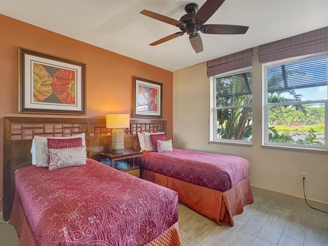 a bedroom with three beds and a window