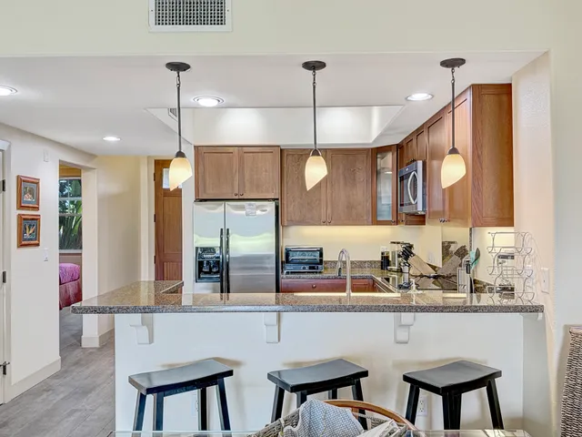 a kitchen with a table chairs refrigerator and microwave