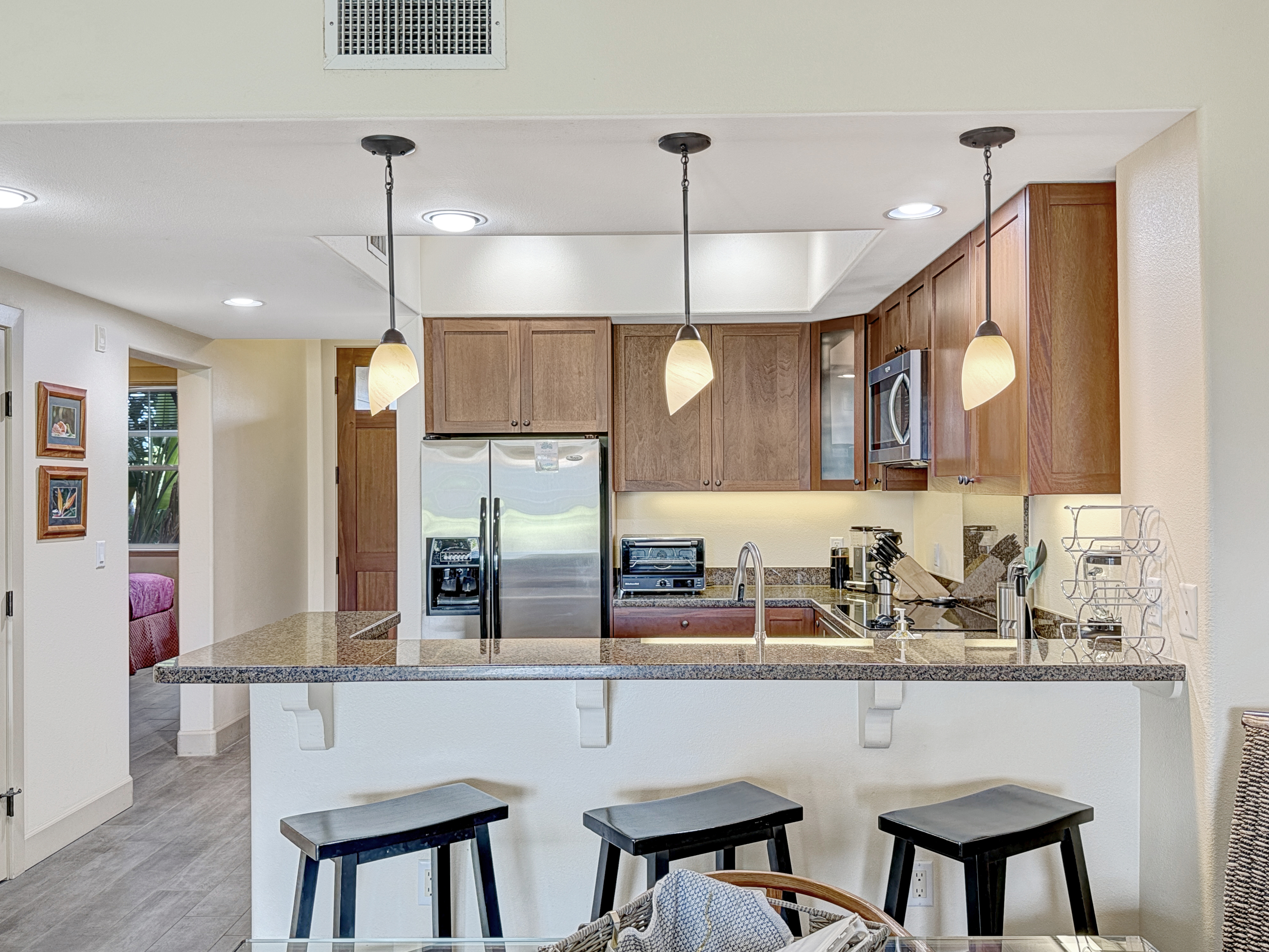 69-1033 Nawahine Place, Unit 9B Waikoloa, HI 96738 - Photo 6 of 24 a kitchen with a table chairs refrigerator and microwave