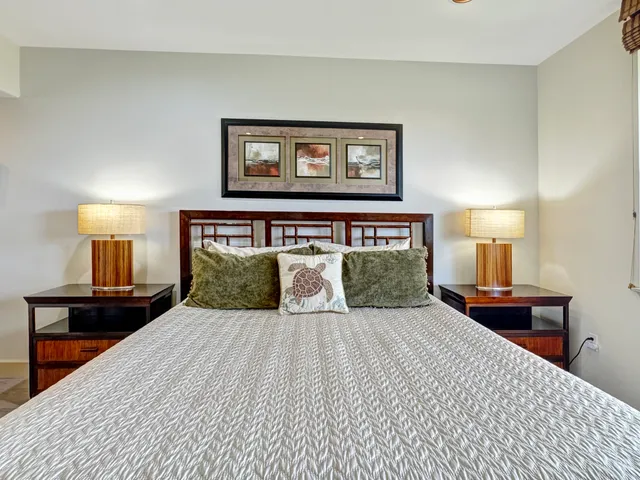 a bedroom with a large bed and a lamp on table