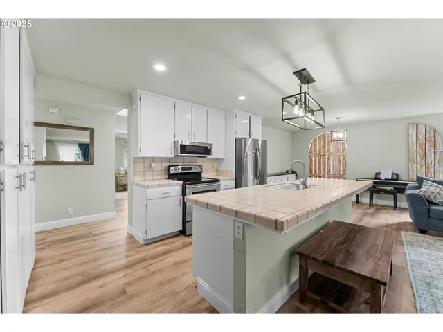 a kitchen with a table chairs refrigerator and microwave