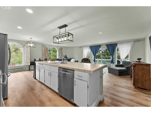 a kitchen with kitchen island granite countertop a sink cabinets and window