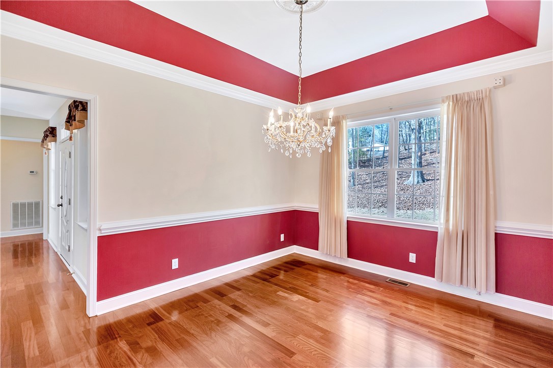 1432 Hunters Trail Anderson, SC 29625 - Photo 12 of 35 Elegant dining space features polished wood floors and a charming chandelier, perfect for entertaining.