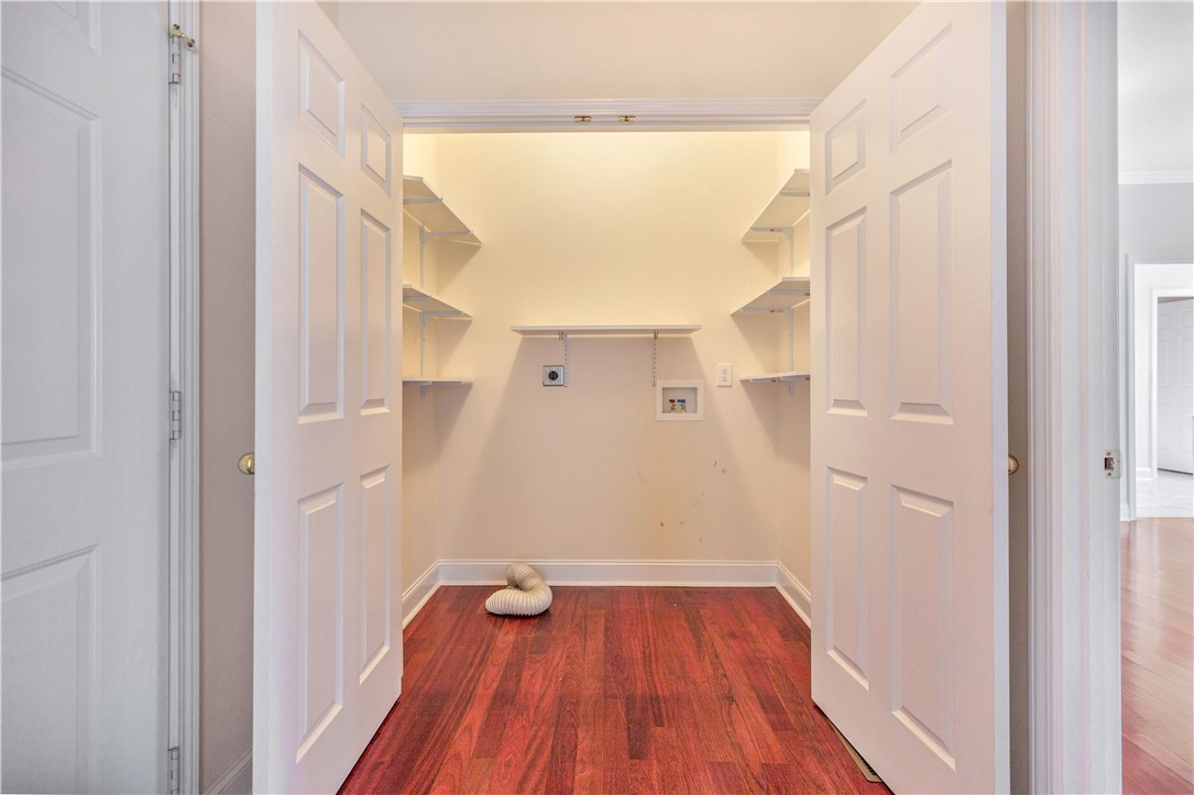 1432 Hunters Trail Anderson, SC 29625 - Photo 18 of 35 This dedicated laundry room features functional shelving, hardwood flooring, and ample space for appliances.