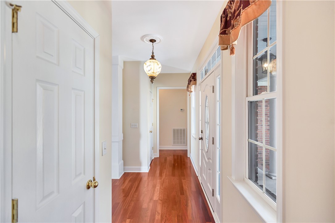 1432 Hunters Trail Anderson, SC 29625 - Photo 4 of 35 This inviting hallway features rich hardwood flooring and a stylish entry door, leading to a bright and welcoming interior.