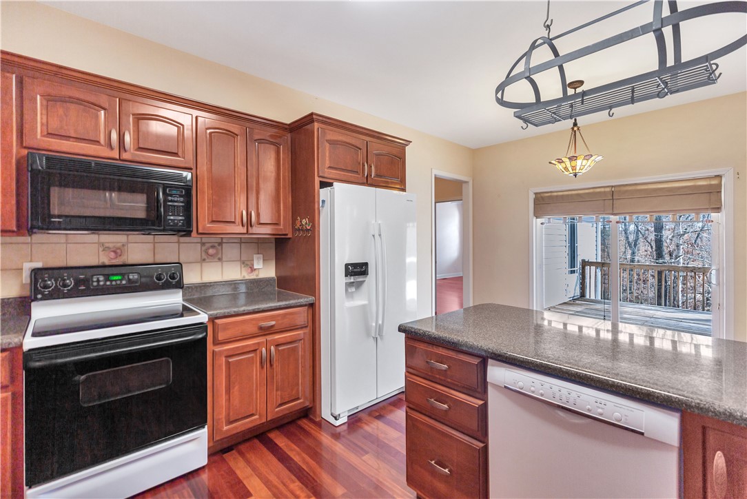 1432 Hunters Trail Anderson, SC 29625 - Photo 10 of 35 This kitchen features rich wood cabinetry, durable countertops, and convenient access to an outdoor deck.