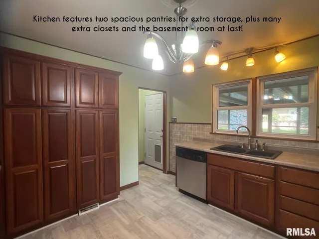 a large kitchen with kitchen island granite countertop a sink stainless steel appliances and cabinets