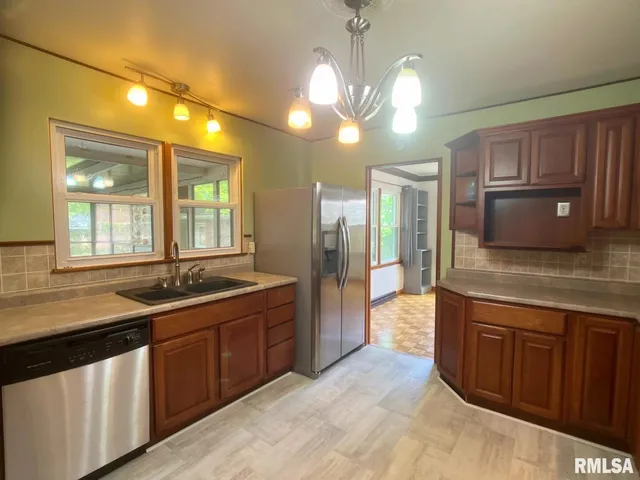 a kitchen with granite countertop cabinets a sink and stainless steel appliances
