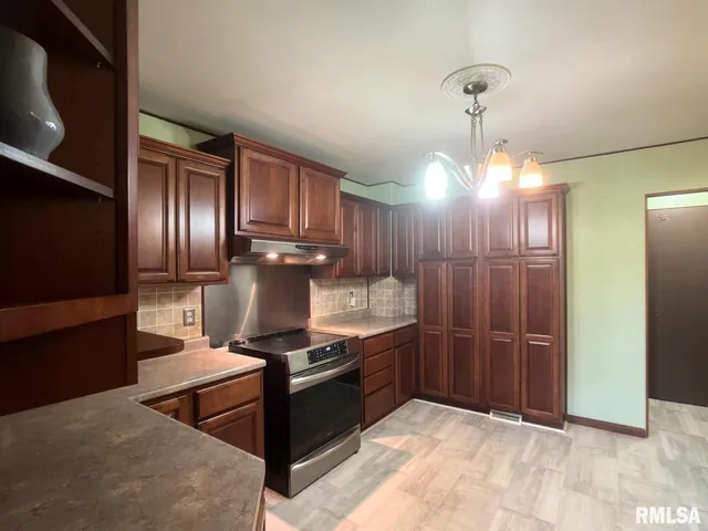 a kitchen with stainless steel appliances granite countertop a stove refrigerator and cabinets