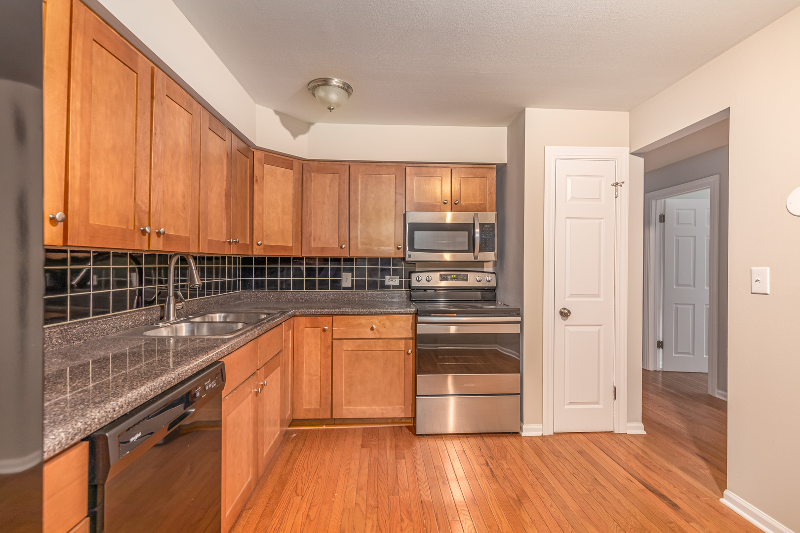 850 South Lorraine Road, Unit 1J Wheaton, IL 60189 - Photo 11 of 22 a kitchen with stainless steel appliances granite countertop a refrigerator a sink and wooden cabinets
