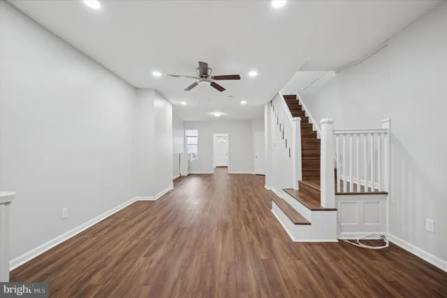a view of a room with wooden floor and ceiling fan