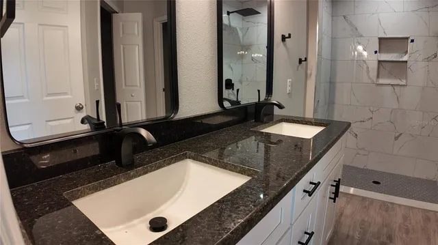 a bathroom with a granite countertop sink and a mirror