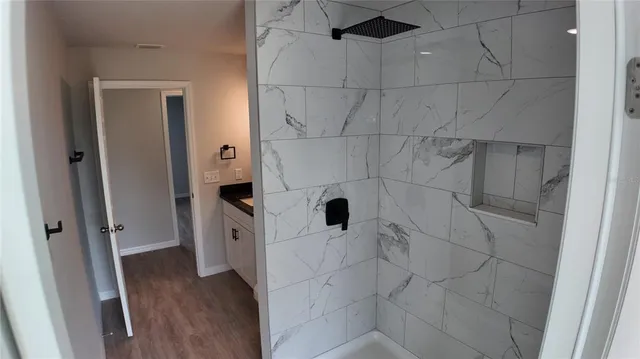 a view of an empty room with a window and wooden floor