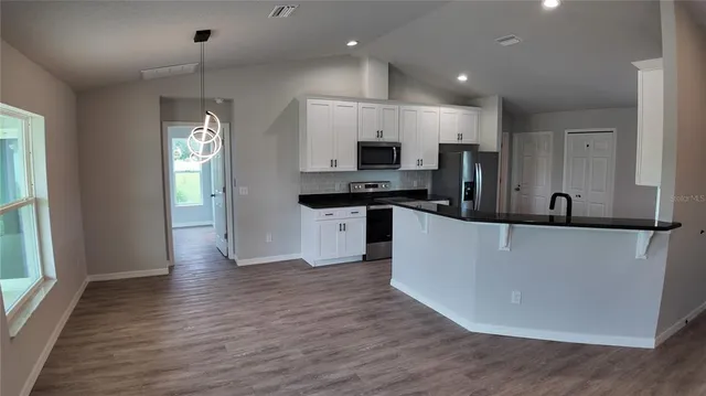 a kitchen with stainless steel appliances a refrigerator sink and microwave