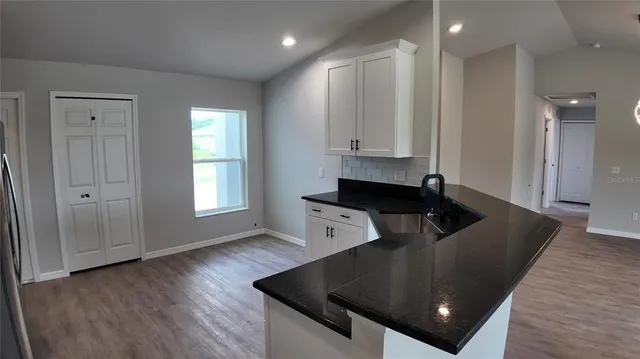 a kitchen with stainless steel appliances granite countertop a sink a stove and a refrigerator