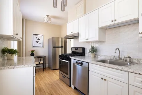 a kitchen with stainless steel appliances granite countertop a refrigerator and a stove top oven