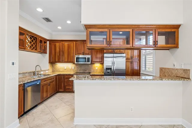 a large kitchen with stainless steel appliances granite countertop a refrigerator and a stove top oven