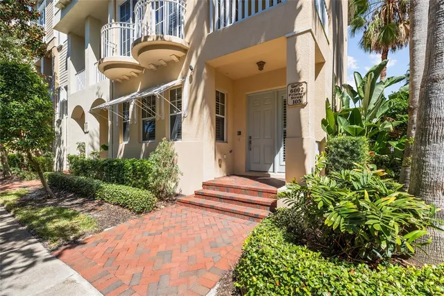 a front view of a house with a yard and tree s