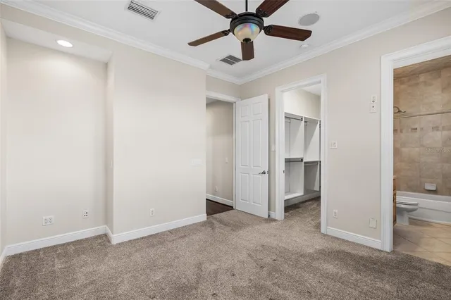 a view of an empty room with a window and a ceiling fan