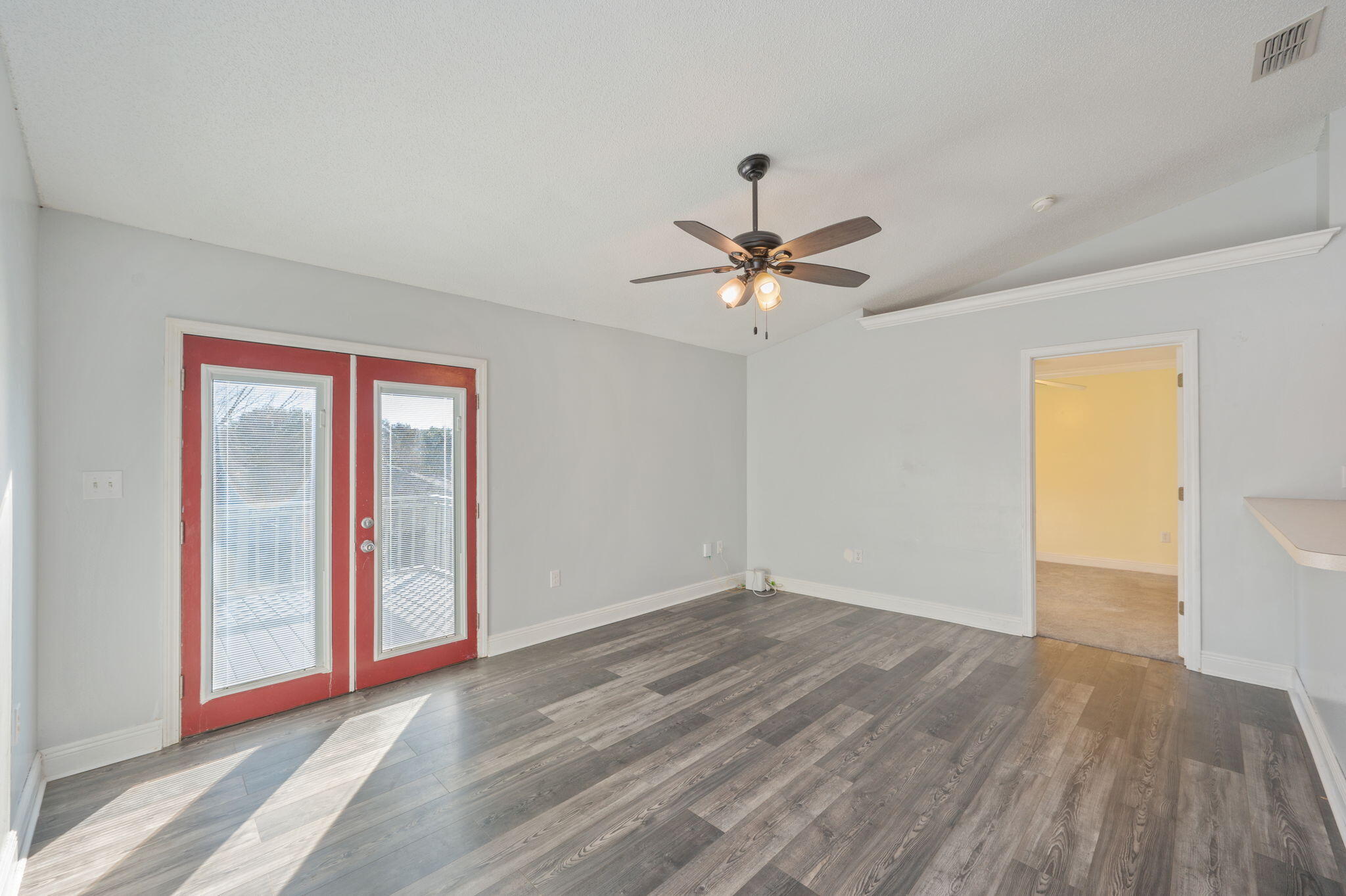 410 Winddrift Court Crestview, FL 32536 - Photo 7 of 44 a view of an empty room with wooden floor and a window