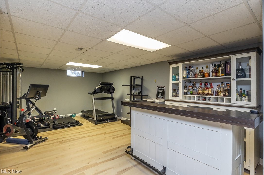 32800 Pettibone Road Solon, OH 44139 - Photo 35 of 49 Exercise area featuring bar, a paneled ceiling, and light hardwood / wood-style flooring