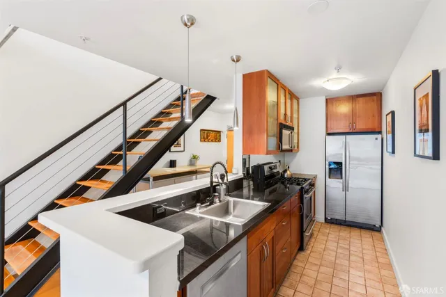 a kitchen that has a sink a stove and a refrigerator