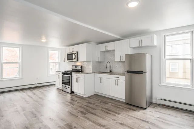 a kitchen with granite countertop white cabinets and white appliances