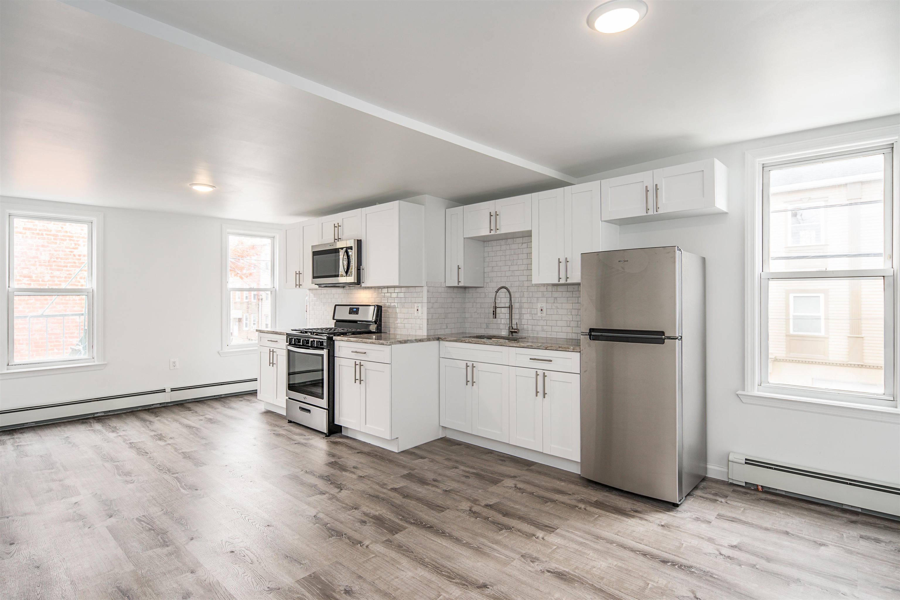 a kitchen with granite countertop white cabinets and white appliances