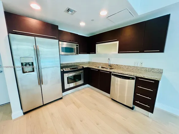 a kitchen with stainless steel appliances kitchen island granite countertop a stove a sink and a microwave