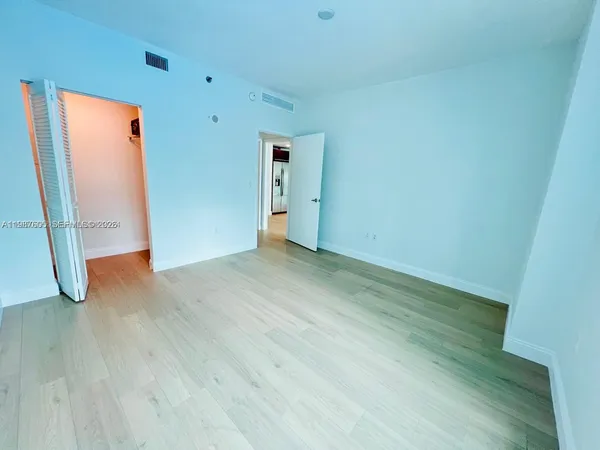 an empty room with wooden floor and door