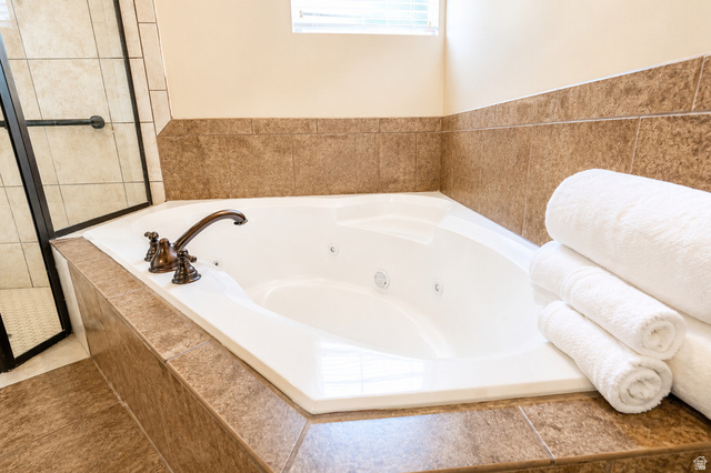 896 Cres Drive South Mapleton, UT 84664 - Photo 19 of 32 Corner soaking tub featuring a bronze-finish faucet, integrated jets, and surrounding brown tile