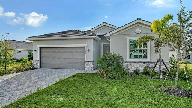 a front view of a house with a garden and plants