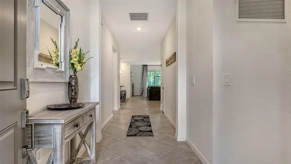 a living room with furniture a chandelier a sink and a flat screen tv
