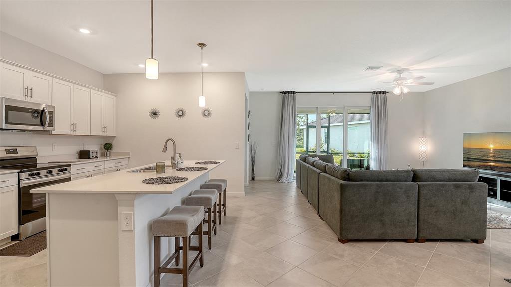 10896 Pinot Drive Venice, FL 34293 - Photo 6 of 70 a living room with furniture a chandelier a sink and a flat screen tv