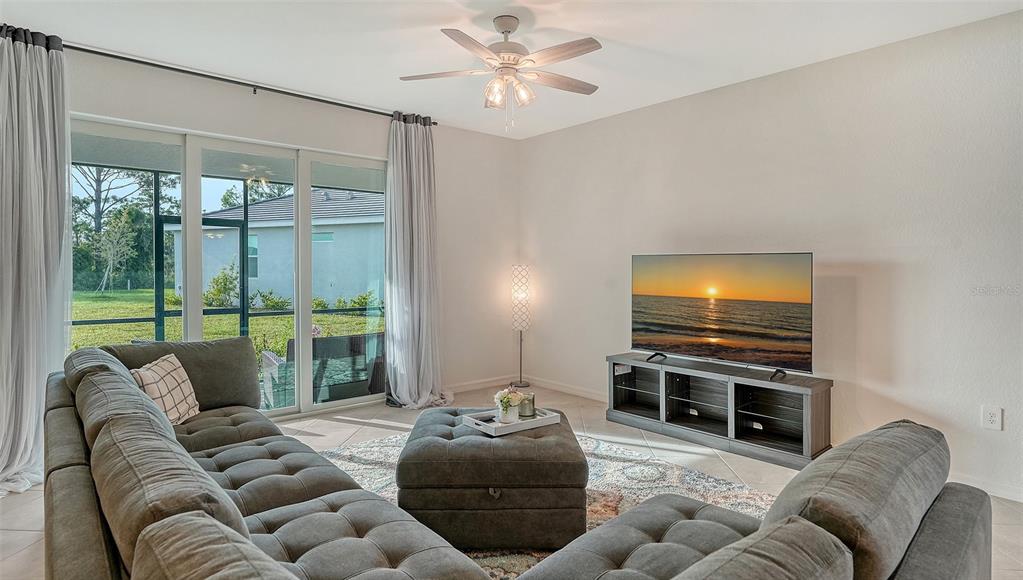 10896 Pinot Drive Venice, FL 34293 - Photo 7 of 70 a living room with furniture a flat screen tv and a large window