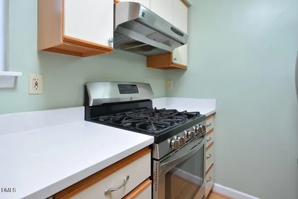 a stove top oven sitting inside of a kitchen