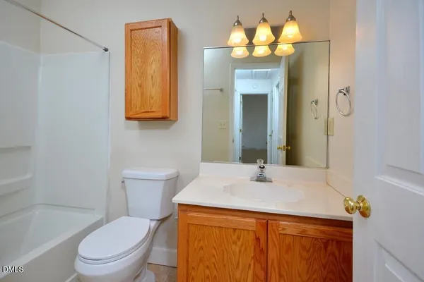 a bathroom with a sink vanity mirror and toilet