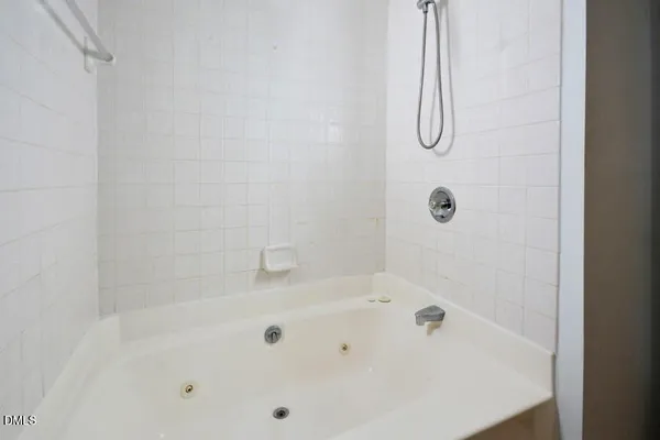a white bath tub sitting next to a white sink and a shower