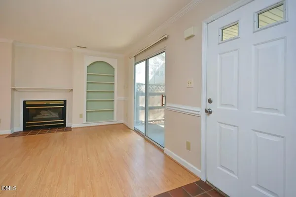 a view of empty room with a fireplace and a window
