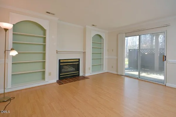 a view of empty room with a fireplace and window