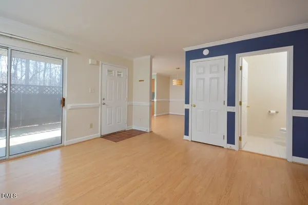 a view of empty room with wooden floor and door
