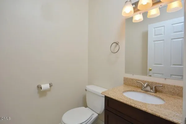 a bathroom with a granite countertop toilet sink and mirror