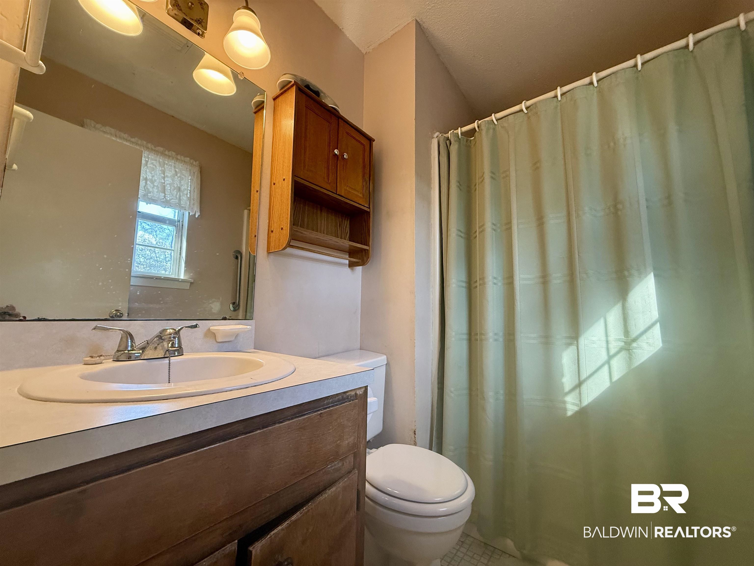 215 Young Street Brewton, AL 36426 - Photo 13 of 25 Full bathroom with vanity and a shower with shower curtain