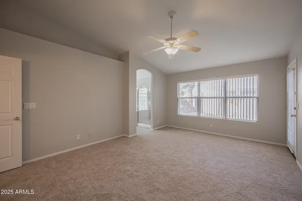an empty room with fan and entrance